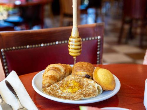 a plate of eggs and croissants on a table at ibis Carcassonne Est la Cité in Carcassonne