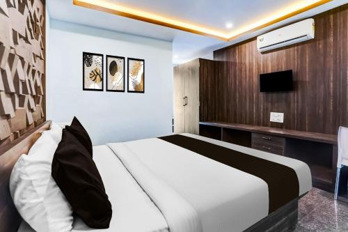 a bedroom with a white bed and a television at FabHotel Arambol Inn in Arambol