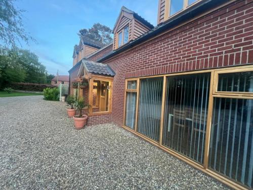 a brick building with sliding glass doors on it at 2 bed in Dereham 86115 in Bawdeswell