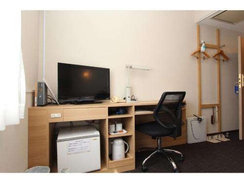 a desk with a television and a chair in a room at Smile Hotel Aomori - Vacation STAY 75478v in Aomori
