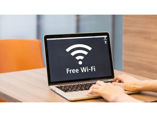 a woman typing on a laptop with a free wifi at Smile Hotel Aomori - Vacation STAY 75478v in Aomori