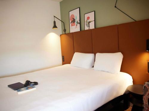 a bedroom with a large white bed with two pillows at ibis Chalon Sur Saone Nord in Chalon-sur-Saône