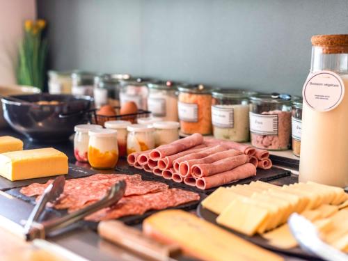 a table topped with meats cheese and other foods at ibis Chalon Sur Saone Nord in Chalon-sur-Saône