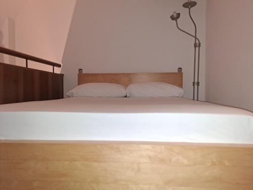 a bedroom with a bed with white sheets and a lamp at Pretty twin Palatina Centro Torino in Turin