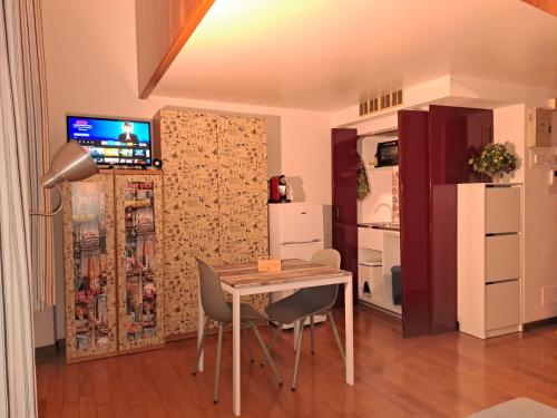 a room with a table and chairs and a kitchen at Pretty twin Palatina Centro Torino in Turin