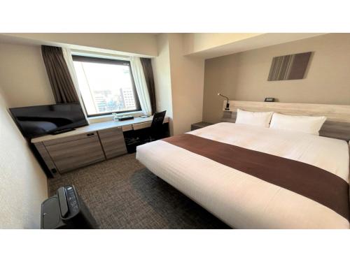 una camera d'albergo con un grande letto e una TV di Smile Hotel Premium Hakodate Goryokaku - Vacation STAY 97568v a Hakodate