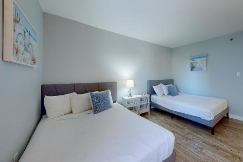 Un dormitorio con dos camas y una mesa con lámpara. en Islander W 306, en Fort Walton Beach