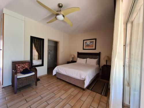 a bedroom with a bed and a ceiling fan at DuneSide Guesthouse in Richards Bay