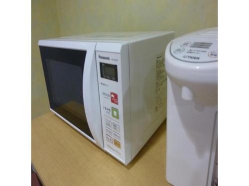 a microwave oven sitting next to a toilet at Smile Hotel Kakegawa - Vacation STAY 12918v in Kakegawa