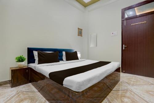 a bedroom with a large bed with a wooden door at SPOT ON Rajshree Homestay Varanasi in Varanasi