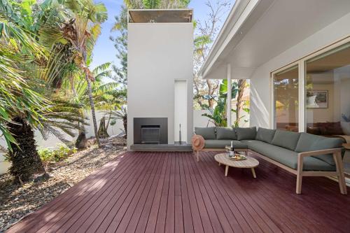 ein Wohnzimmer mit Sofa und Tisch in der Unterkunft Beachside Bungalow on Shelly Beach in Caloundra