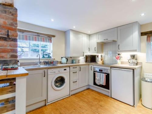 a kitchen with white cabinets and a washer and dryer at 1 Bed in Pershore REDCO in Upton Snodsbury