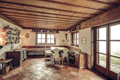 a kitchen with a table and chairs and windows at Bergidyll Heiligenblut am Glockner in Heiligenblut