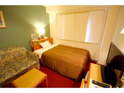 a hotel room with a bed and a couch at Smile Hotel Tokyo Shinkoiwa - Vacation STAY 82171v in Tokyo