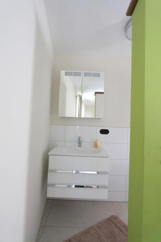 a white bathroom with a sink and a mirror at Winter'sches Haus in Nördlingen