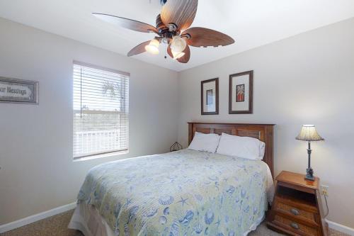 a bedroom with a bed and a ceiling fan at Grand Caribbean 121 in Orange Beach