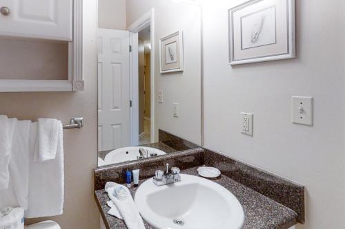 a bathroom with a sink and a mirror at Grand Caribbean 121 in Orange Beach