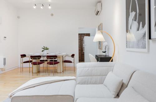 a living room with a white couch and a table at La Galerie Privée Luxe & Impeccable Stay in Montréal