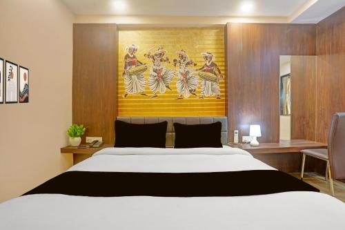a bedroom with a bed and a painting on the wall at Townhouse Oak City Centre Dhanbad Formerly Hotel Kuber Inn in Dhanbād