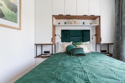 a bedroom with a large green bed with pillows at HappyDeer - Ekskluzywny apartament z widokiem na góry in Jelenia Góra