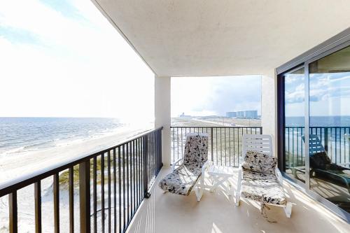 a balcony with two chairs and a view of the ocean at Wind Drift 512S in Perdido Key