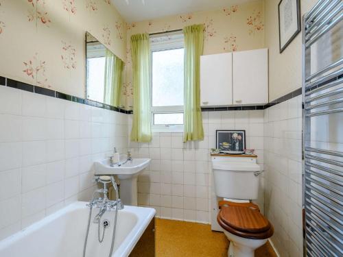 ein Badezimmer mit Toilette, Waschbecken und Badewanne in der Unterkunft 3 Bed in Oban 86398 in Oban