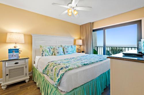 パナマ・シティ・ビーチにあるThe Commodore #302Bのベッドルーム1室(天井ファン、窓付)