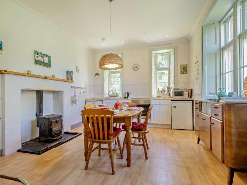 cocina con mesa, sillas y chimenea en 2 Bed in Lochgilphead AG577, en Kilmartin