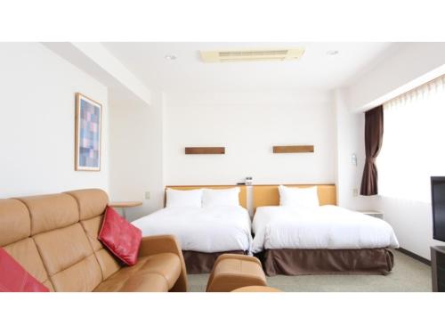 東根市にあるSmile Hotel Sakurambo Higashine - Vacation STAY 30018vのベッド2台とソファのあるリビングルーム