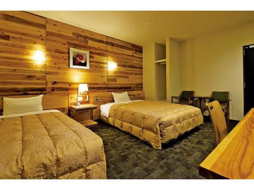 a hotel room with two beds and a wooden wall at Maniwa City Hotel Sunrise - Vacation STAY 98584v in Maniwa