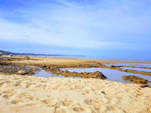 a sandy beach with a pool of water in the sand at 2 Bed in Filey 89281 in Hunmanby