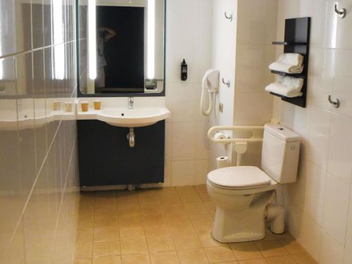 a bathroom with a toilet and a sink and a mirror at ibis Laval Le Relais D'Armor in Laval
