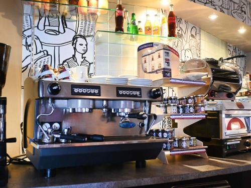 a kitchen with a coffee machine on a counter at ibis Laval Le Relais D'Armor in Laval