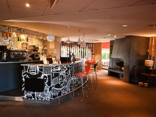 a bar in a restaurant with red bar stools at ibis Laval Le Relais D'Armor in Laval