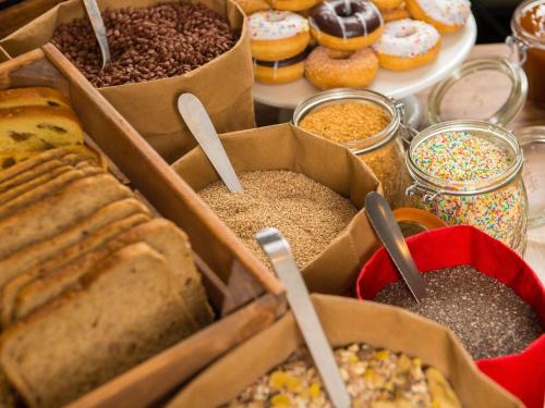 a table topped with boxes of different types of bread and pastries at ibis Lorient Centre Hôtelier in Caudan