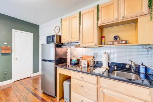 a kitchen with wooden cabinets and a stainless steel refrigerator at OLD TOWN Nature Oasis Block 2 King 99 Walk Score in Alexandria