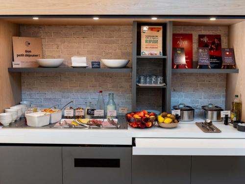 a kitchen counter with fruits and other food on it at ibis Lyon Est Bron in Bron