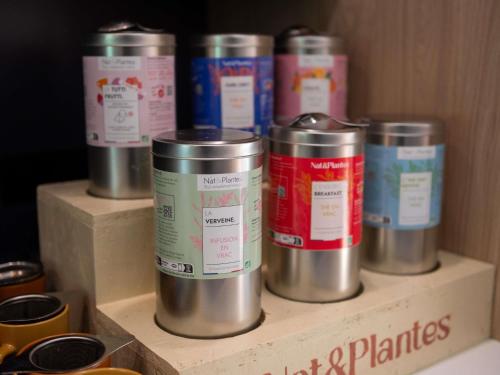 a row of metal canisters on a wooden shelf at ibis Lyon Est Bron in Bron