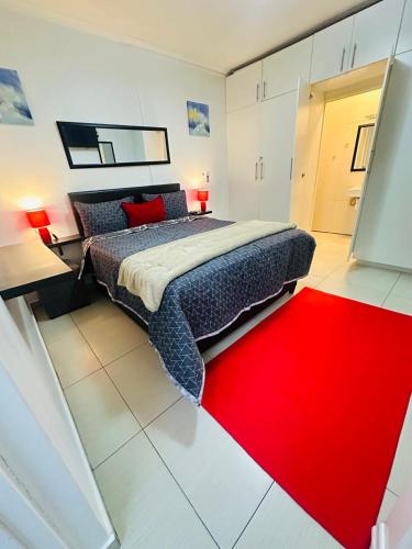 a bedroom with a large bed and a red rug at Surrey B&B in Surrey Estate
