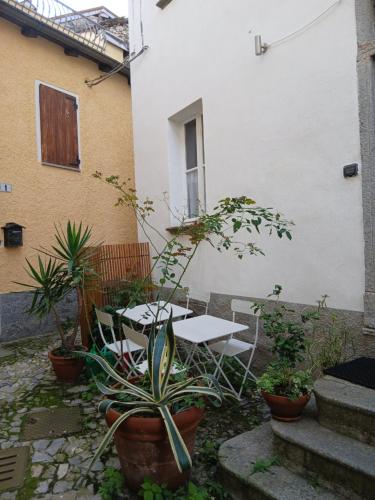 a patio with a table and chairs and plants at Casa Giacomina in Perledo