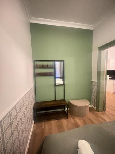 a room with green walls and a bench and a window at Belvedere Old Town with Balcony AC Progres in Toruń