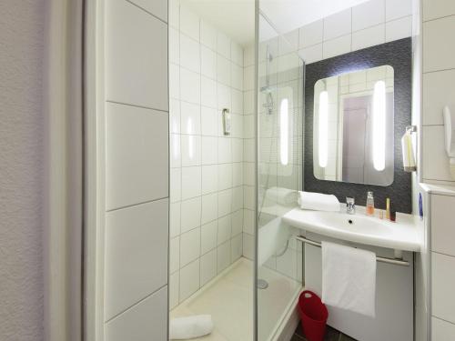 モンペリエにあるibis Montpellier Sudの洗面台と鏡のある白いバスルーム