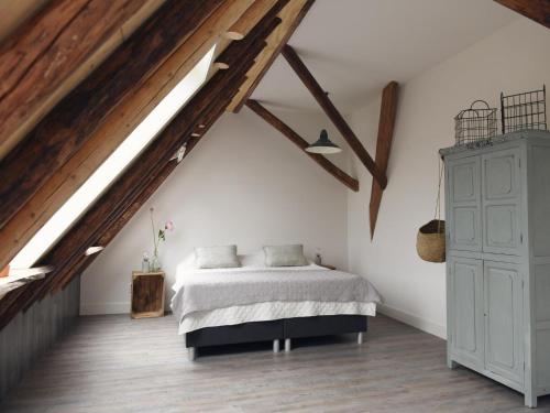 a bedroom with a bed and a wooden ceiling at Apartment with Garden in Dutch Countryside in Callantsoog