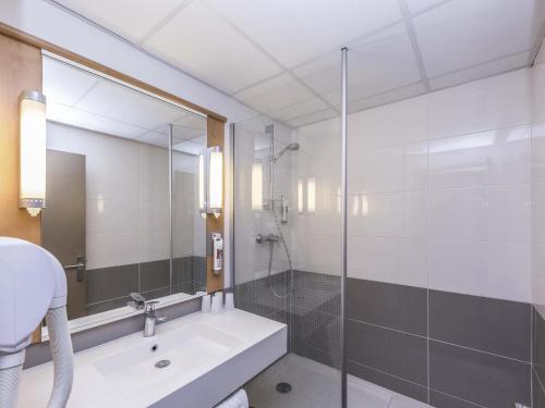 a bathroom with a glass shower and a sink at ibis Montélimar Nord in Saulce-sur-Rhône