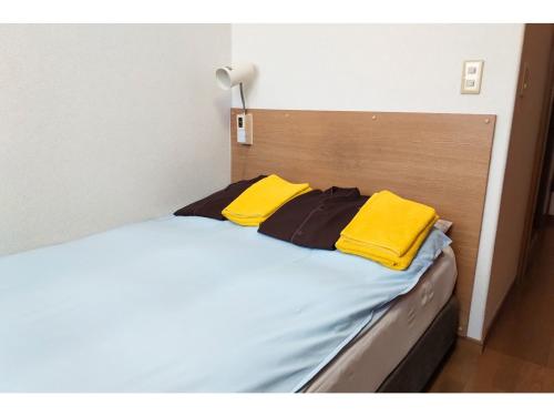 a bed with two yellow towels on top of it at Hotel Pacific - Vacation STAY 29745v in Ishinomaki