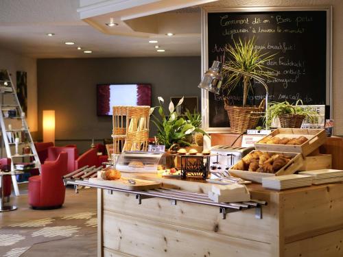 a bakery with a counter with bread and pastries on it at ibis Nemours in Nemours
