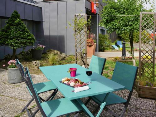 a blue table with a plate of food and a glass of wine at ibis Nemours in Nemours