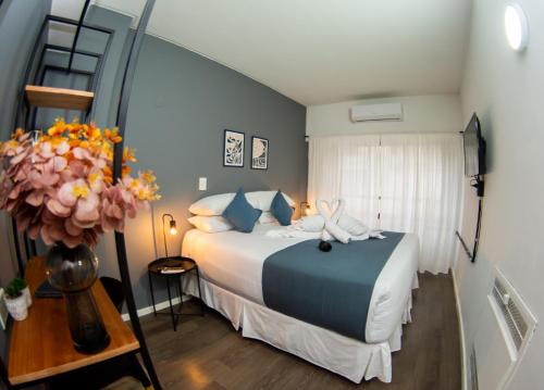 a bedroom with a bed and a vase of flowers at El Misti Suites Buenos Aires in Buenos Aires
