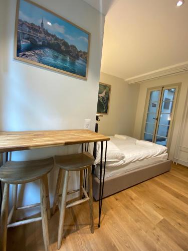 a room with a desk and a bed in the background at Tiny Old Town Studio in Bern
