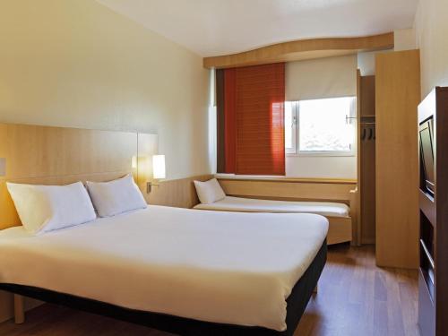 a hotel room with two beds and a window at ibis Paris Porte d'Italie in Paris